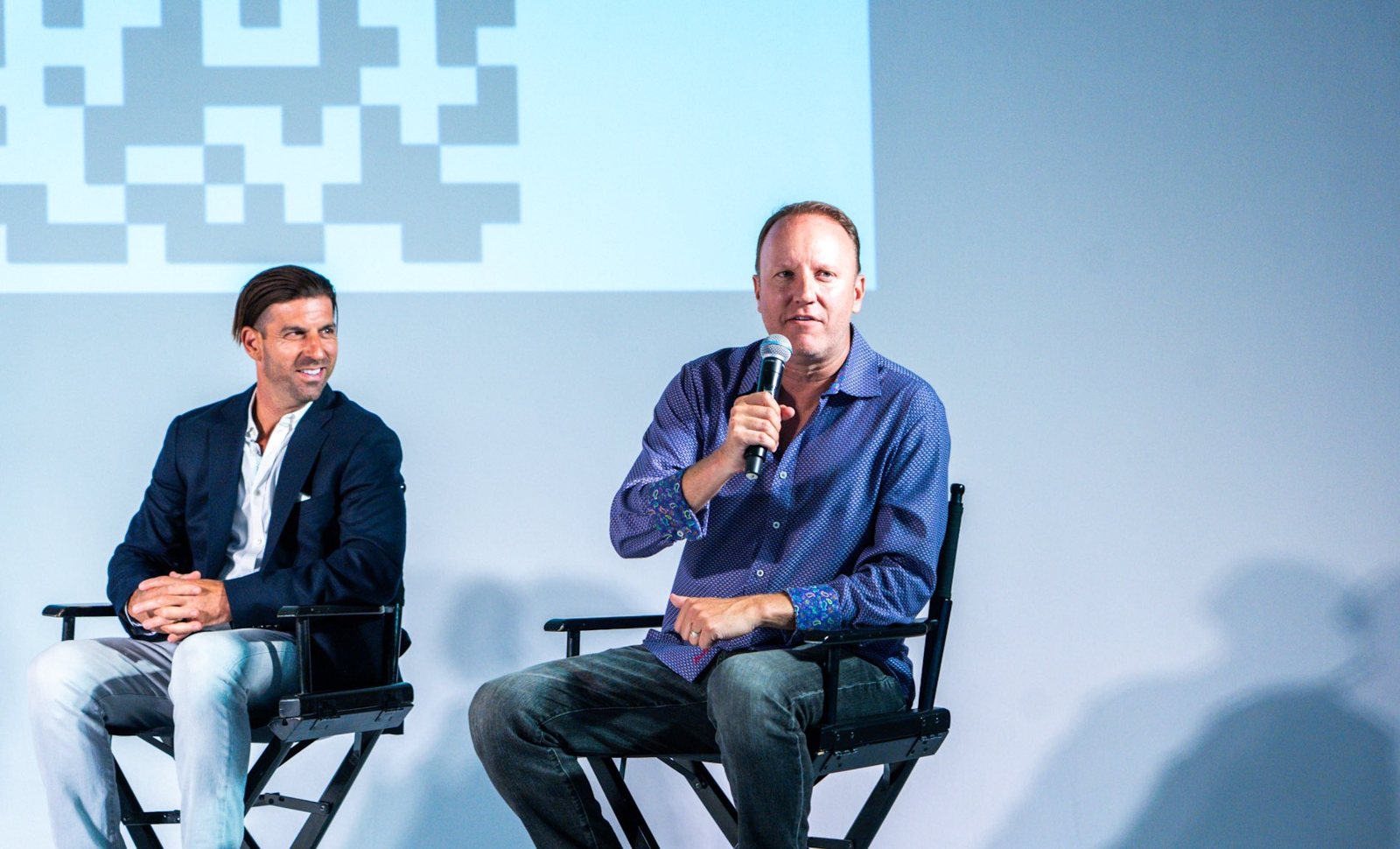 Darren Marble on stage with a microphone at the Season 2 launch of Going Public